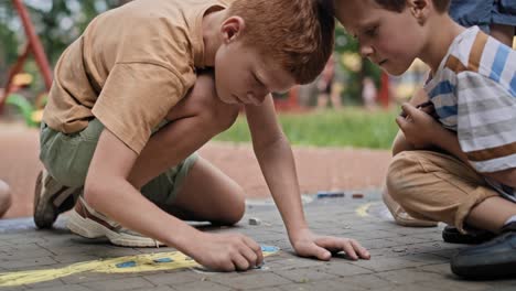 Gruppe-Kaukasischer-Kinder,-Die-An-Einem-Sommertag-Im-Park-Mit-Kreide-Färben.