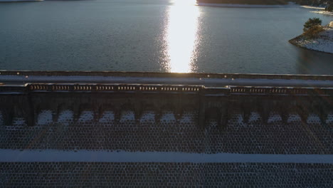 aerial view of a snow-covered dam at sunset