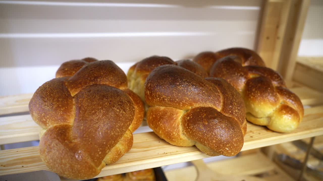 Display of braided bread loaves on a wooden shelf