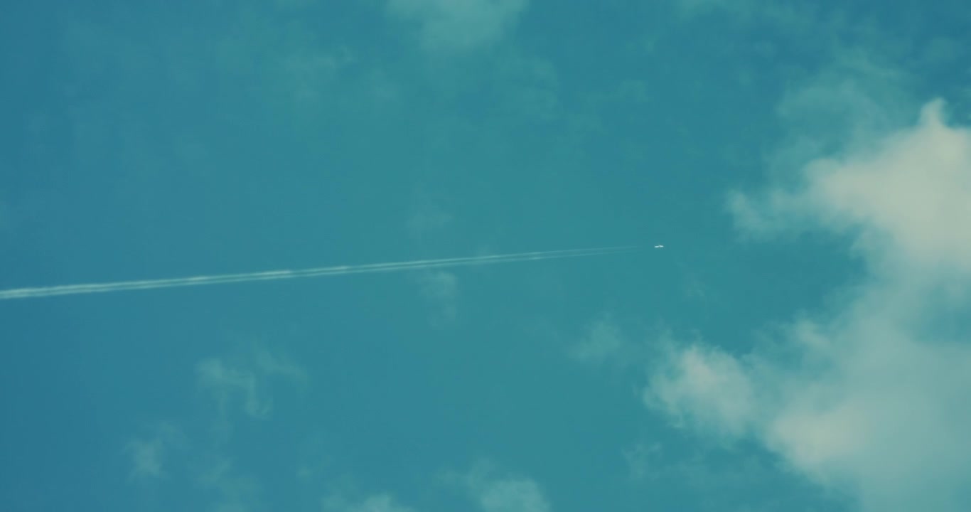 Flystriber strækker sig over en klar himmel med spredte skyer. Kommerciel flytransport og rejsekoncept under sommerferien.