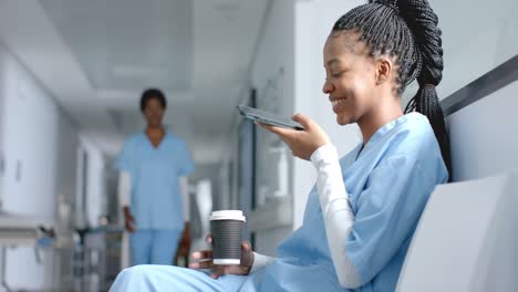 Doctora-Afroamericana-Hablando-Por-Teléfono-Inteligente-En-El-Hospital,-Cámara-Lenta