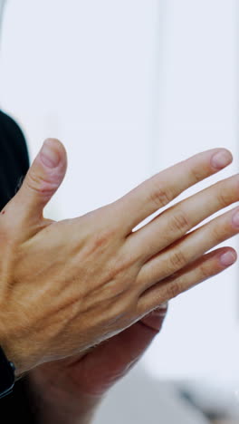 male hands in praying position. unrecognized man in black t-shirt rubbing his hands nervously. close up. vertical video