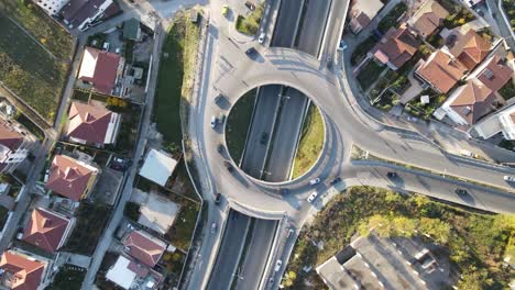 Vista-Aérea-De-Drones-De-La-Carretera-De-Cruce-De-Varios-Niveles-Con-Camiones-En-Movimiento-Al-Atardecer