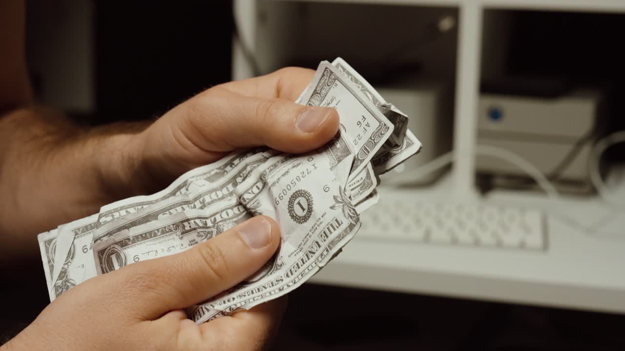 Hænder, der tæller dollarsedler foran en computer. Konceptet med at tjene penge på kryptovaluta-mining, digital finans og onlineindkomst.