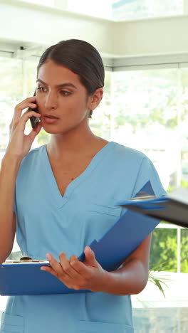 médicos sosteniendo el portapapeles y haciendo una llamada telefónica