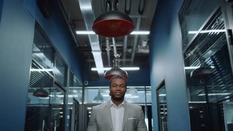 friendly afro man looking at camera in office. businessman waiting for meetup