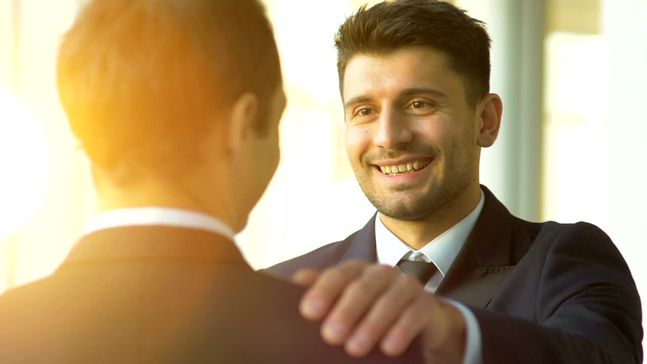 los hombres de negocios le dan una palmadita en el hombro.