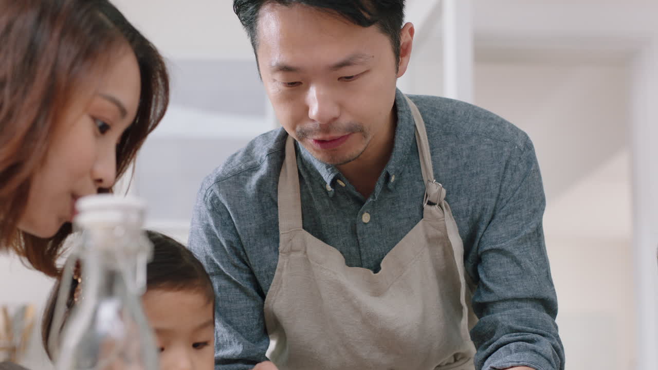 幸せなアジアの家族が朝食にパンケーキを食べる 子供たちが週末の朝,両親と一緒に健康的な家庭料理を楽しんでいる 厨房の4k映像