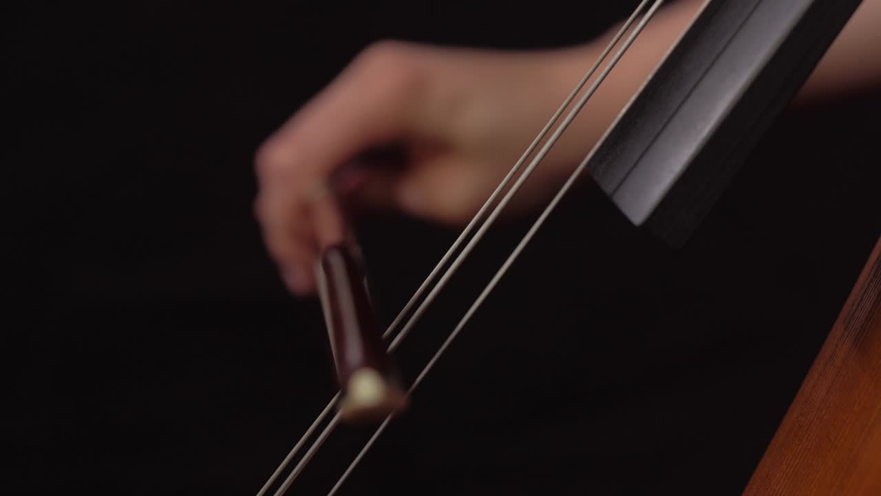 close up of woman playing cello with bow
