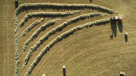 luftansicht von traktoren, die strohballen ernten.