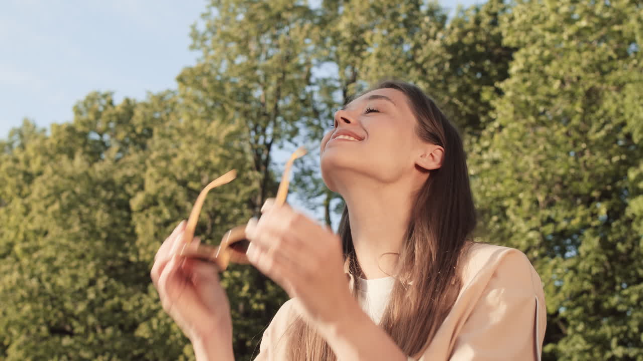Woman Taking Sunglasses off in Park