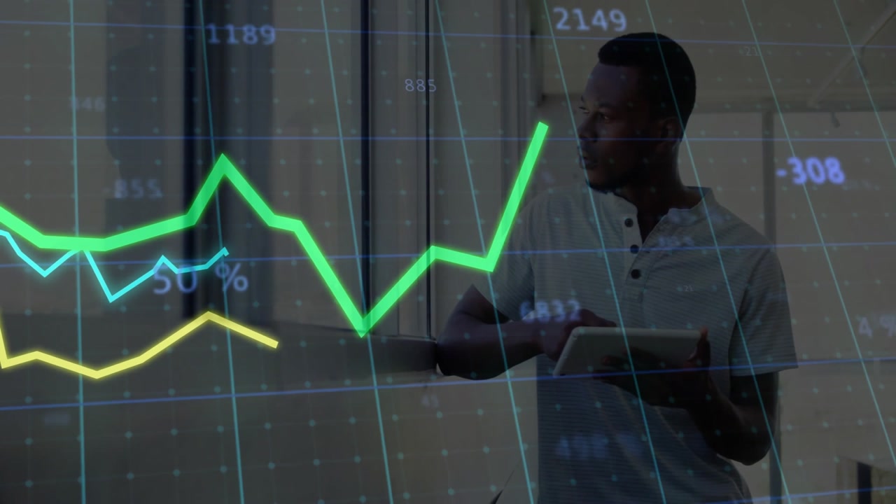 Male data analyst holding tablet tracing trend lines after fade-in analyzing business performance