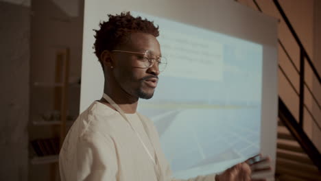 young man giving presentation on energy efficient architecture during seminar