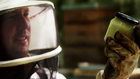 beekeeper holding a bottle of beeswax