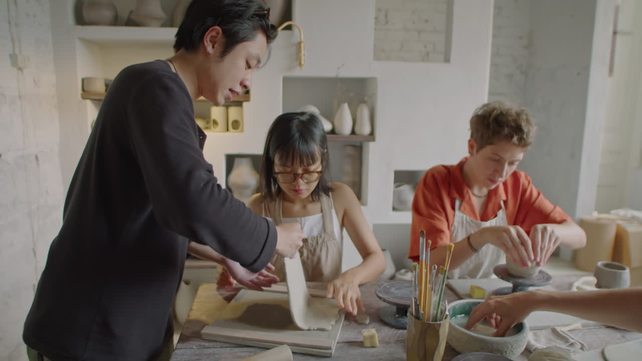 Ceramist Teaching Students Rolling Clay On Pottery Masterclass
