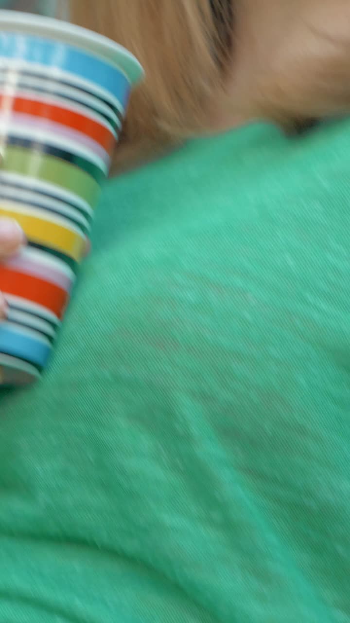 Woman drinking from a striped cup