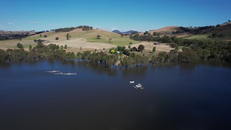 jet ski passing fishing boats on lake eildon aerial landscape, victoria