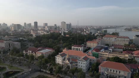 low aerial pan over river city buildings of phnom penh, cambodia