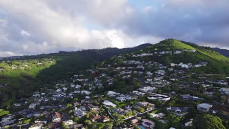 pan-left-drone-shot-of-the-residential-area-of-Oahu-just-outside-Honolulu-on-the-island-of-Oahu-with-buildings-and-houses-built-up-the-side-of-the-mountain