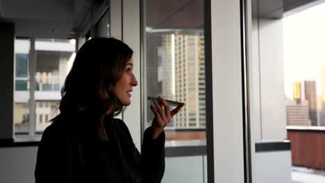 Side-view-of-beautiful-Caucasian-Businesswoman-talking-on-mobile-phone-in-a-modern-hotel-4k