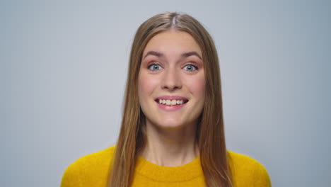 Portrait-of-attractive-woman-shaking-yes-with-head-on-grey-background.