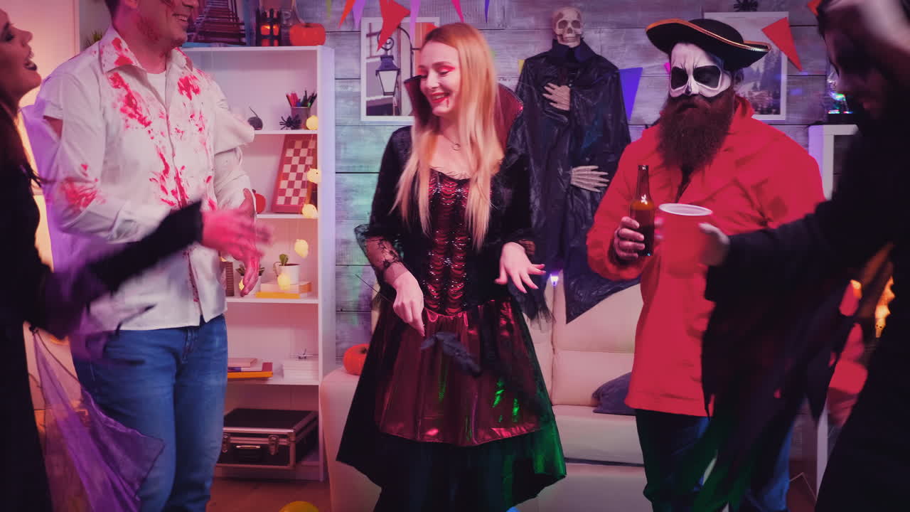 Group of happy people having fun and dancing at halloween party