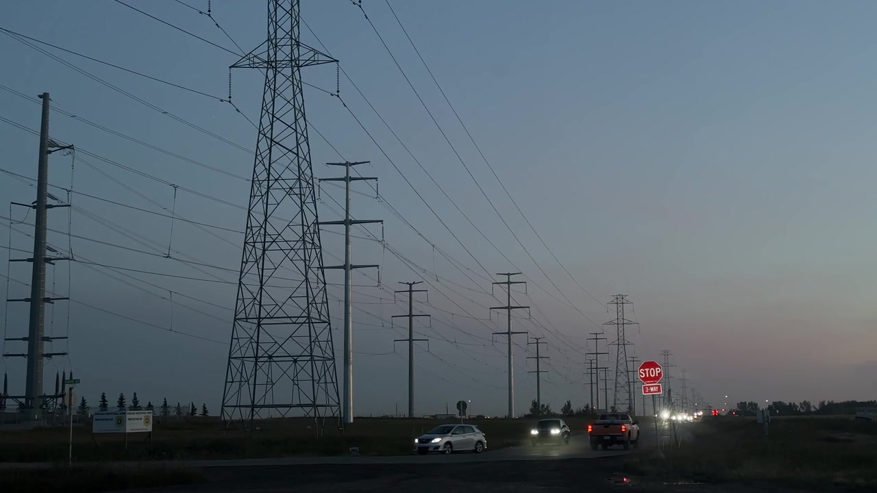 High Voltage Power lines with road traffic sunrise, evening