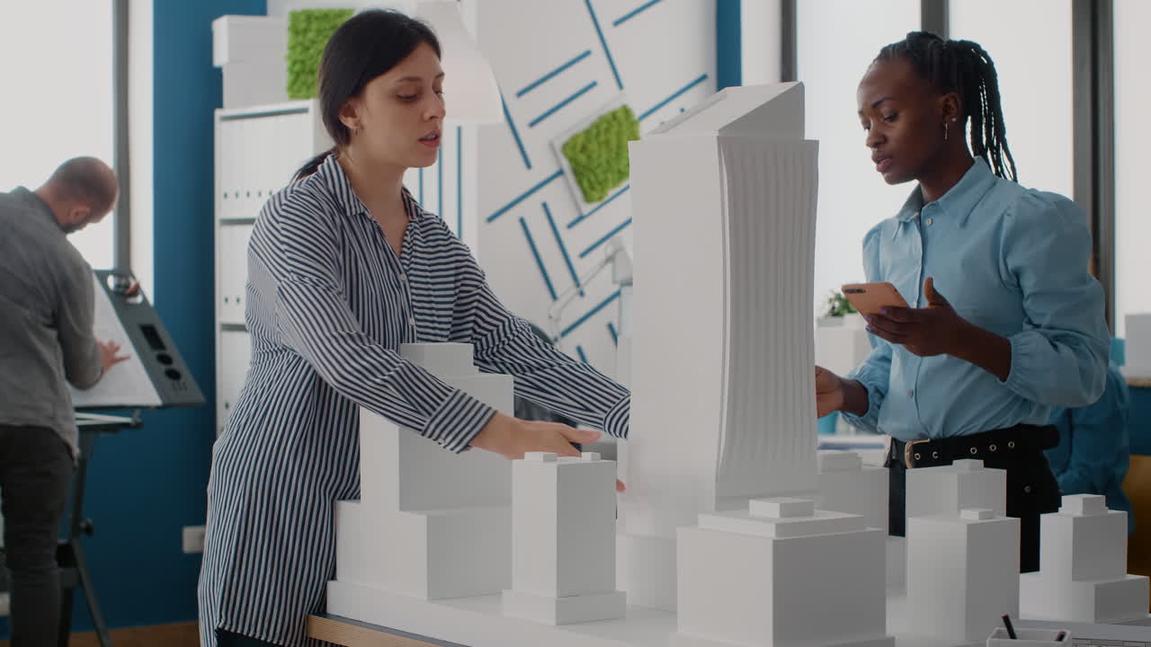 Two architects examining a building model