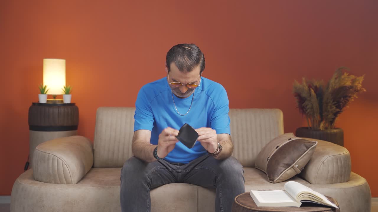 빈 지갑을 바라보는 빈곤한 남자.