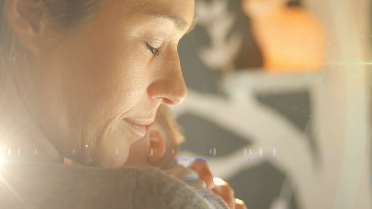 animación de manchas brillantes sobre una madre caucásica feliz con un bebé durmiendo