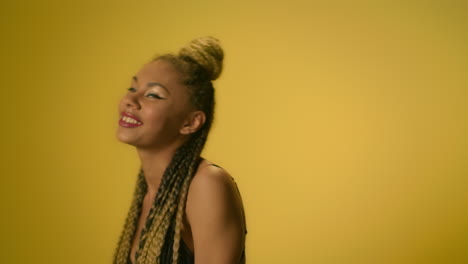 african american woman with dreadlocks dancing in slow motion on yellow