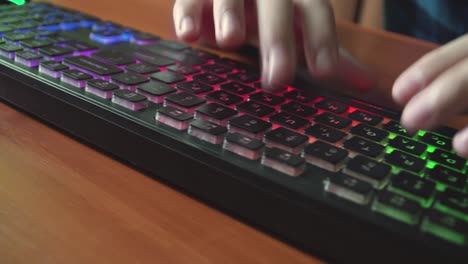 un hombre escribe texto en un teclado retroiluminado 02