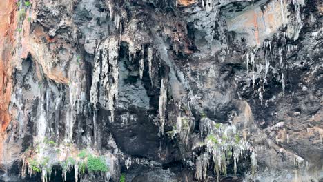 cliff face with stalactites and turquoise water