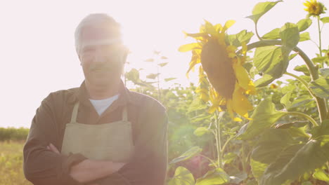 smiling farmer with sunflower in field