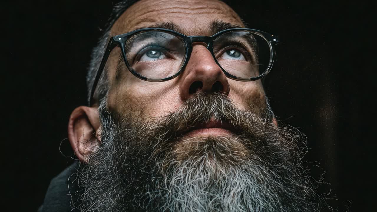 An Introspective Journey: Capturing the Depth of Emotion in a Bearded Man’s Fascinating Gaze Through Two Powerful Frames