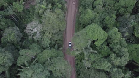 Dirt-Road-With-Traveling-Vehicle-Pass-By-Dense-Tropical-Forest-In-Colombia