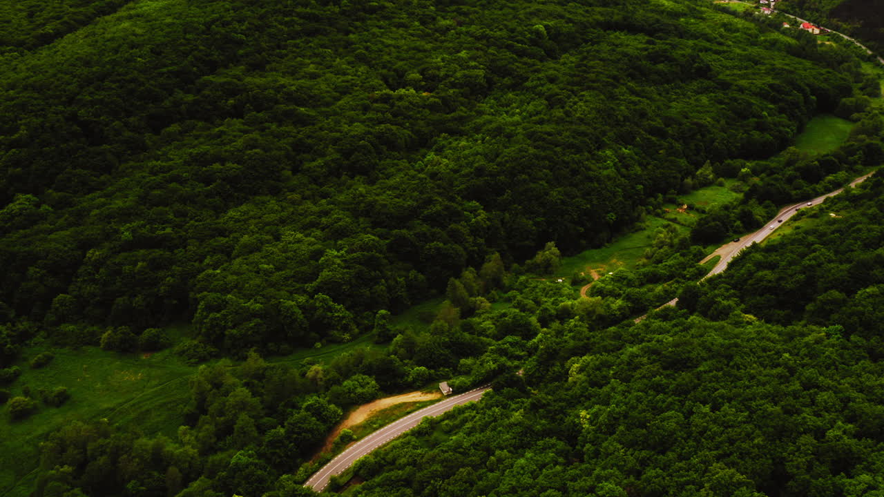 vista aérea del paisaje de drones sobre una carretera de montaña que serpentea a través de un bosque rumano