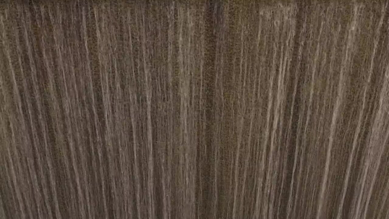 Vista detalhada de filetes verticais de água caindo criando um padrão texturizado em uma cachoeira.