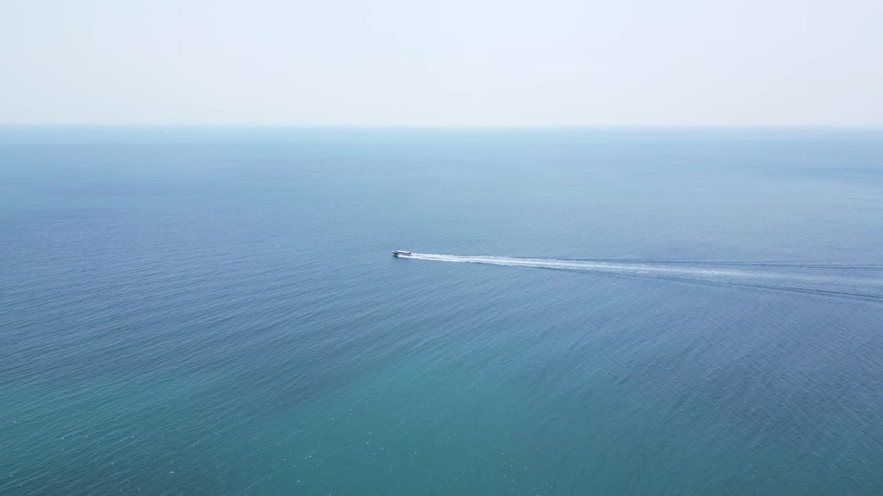 드론은 열린 바다 위를 빠르게 달리는 보트를 따라갑니다.