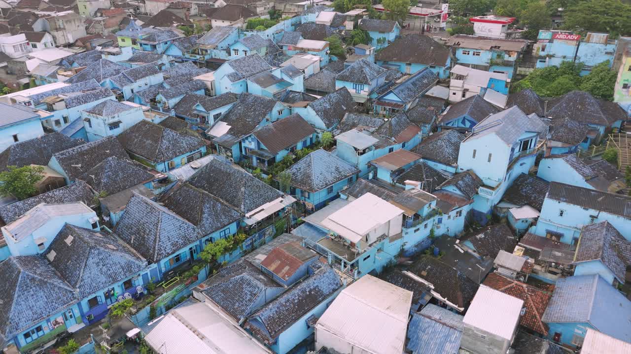Drone Fly above blue houses neighborhood of Rainbow Village Malang East Java Indonesia establishing shot of famous area at daylight