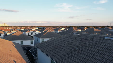 Aerial-view-low-over-sunlit-neighborhood-homes,-sunny-evening-in-Florida,-USA