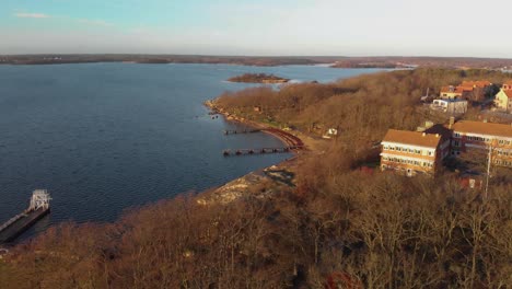 Tomas-Aéreas-Sobre-Una-Playa-En-Salto-Karlskrona,-Suecia-Llamada-Saltos-Y-También-Mostrando-Una-Escuela-En-La-Montaña-1