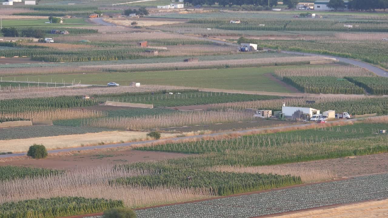 Vue panoramique de routes rurales et de paysages agricoles variés à Grenade. Des véhicules traversent les terres agricoles sous la lumière naturelle du soleil couchant. Concept de logistique rurale et de production alimentaire durable.