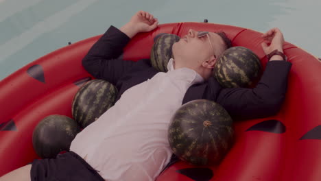 man relaxing on a watermelon inflatable pool float