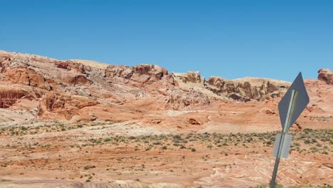 On-the-road-through-stunning-red-hills-of-the-Valley-of-Fire-state-park-in-Nevada