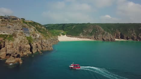 excursión en barco frente a la playa de porthcurno, costa de cornualles en verano, vista aérea