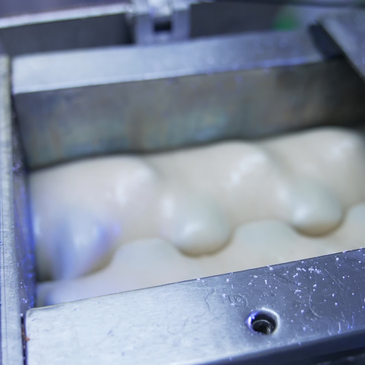 White liquid substance being mixed in a special tank. Milky stuff being mixed and whipped by nozzles in automatic machine. Confectionary production concept