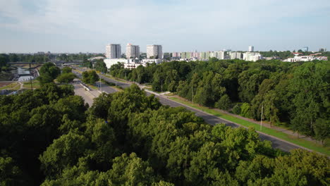 воздушный прямой полет над лесом, дорогой и жилым кварталом района варшавы на заднем плане