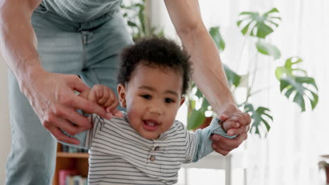 father helping baby learn to walk