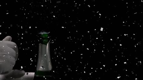 confetti falling over mid section of person opening a champagne bottle against black background